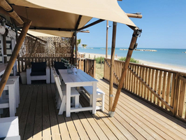 Luxe Tent Silver Seaview : De ruime veranda met eettafel en lekker zitje met zeezicht